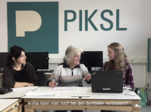 Drei Frauen sitzen nebeneinander vor einem Computer im PIKSL Computerraum.