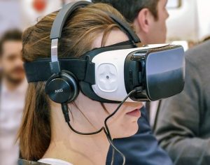 Ein junges Mädchen mit einer VR-Brille und Kopfhörern auf dem Kopf
