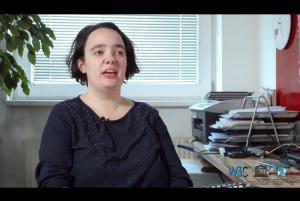 A woman sitting at a desk, talking