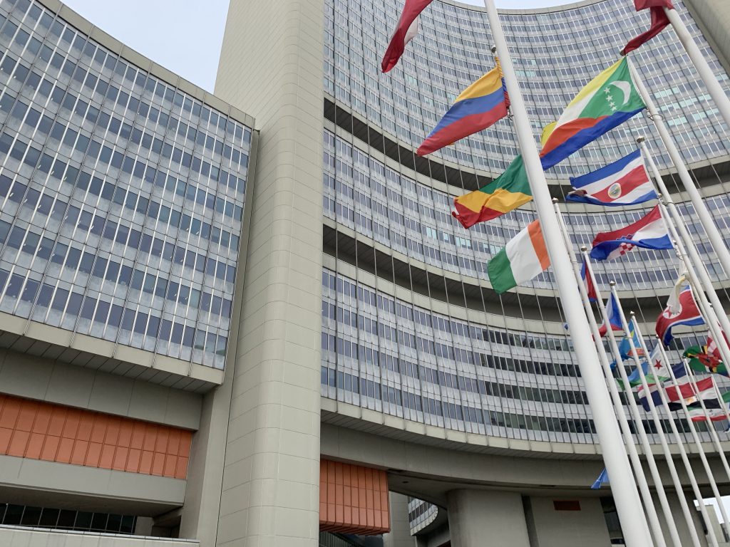 The United Nations building from the outside. The different national flags of the UN members are waving in the wind.